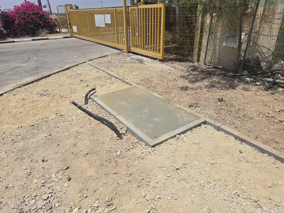 תקריב של בסיס הבטון והצנרת לפני התקנת הסמל