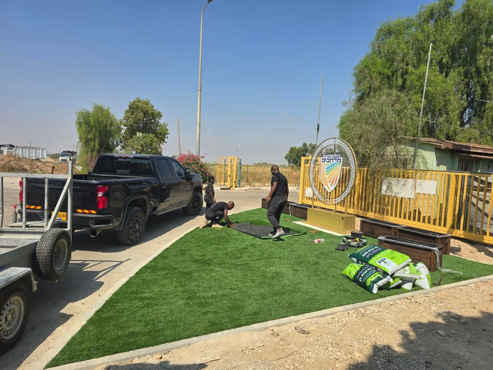 צוות העבודה מתקין את הסמל והאדניות במתחם המוכן